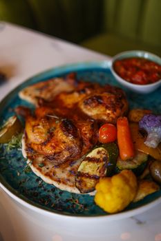 A tempting plate of grilled chicken served with assorted roasted vegetables for a perfect meal.