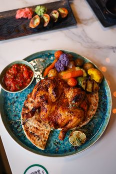 Savor a gourmet roasted chicken with vibrant vegetables and zesty salsa on artisan naan.