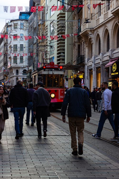 Free Busy Istiklal Street in Istanbul with a red tram, people, and flags. Stock Photo