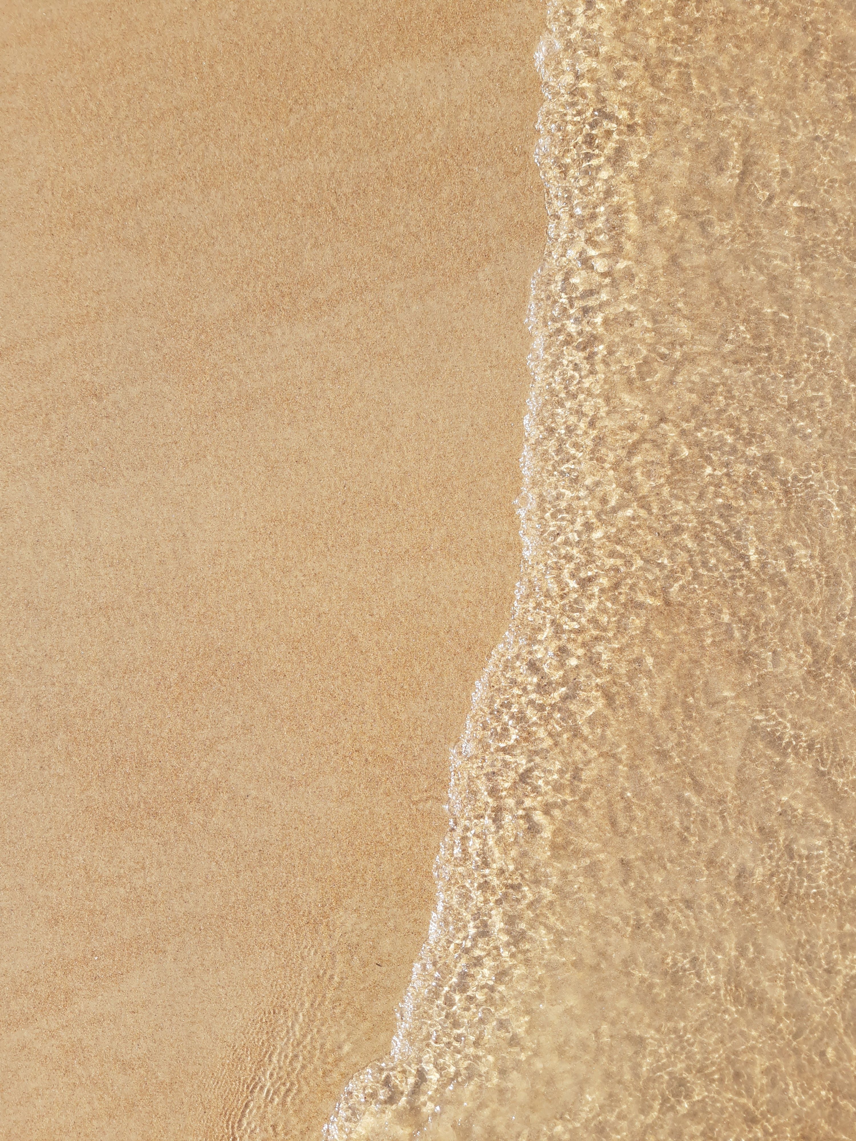 Peaceful beach scene with waves lapping on a sandy shore, perfect for relaxation themes.