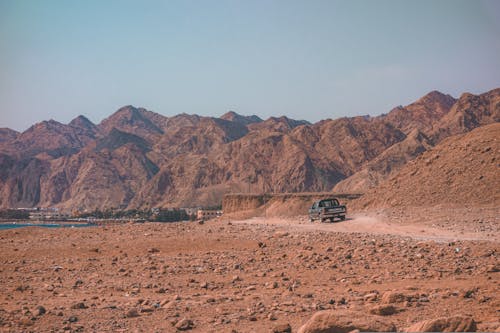 A Car Driving on the Road in the Desert 