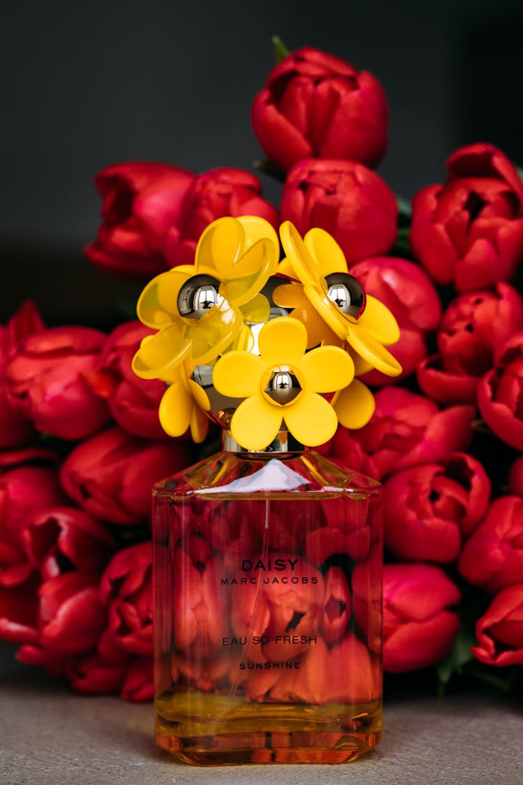 Female Perfume Against Red Tulips Bouquet