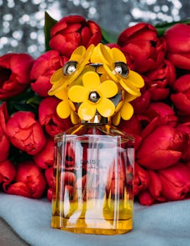 在室内拍摄的色彩缤纷的香水瓶，搭配鲜红色郁金香，营造出优雅的花卉装饰