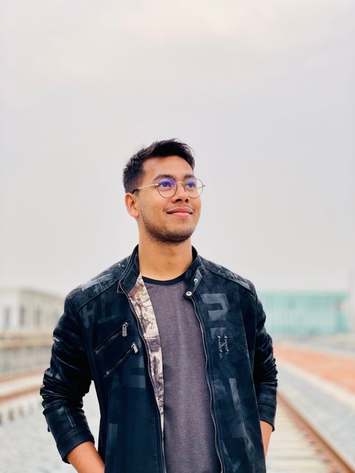 Free Portrait of a smiling young man with short hair and eyeglasses standing confidently outdoors. Stock Photo