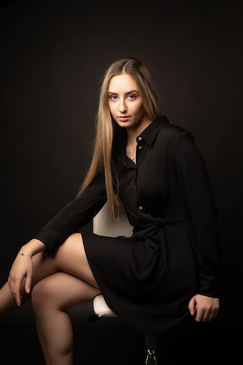 Blonde Woman Sitting in Black Dress