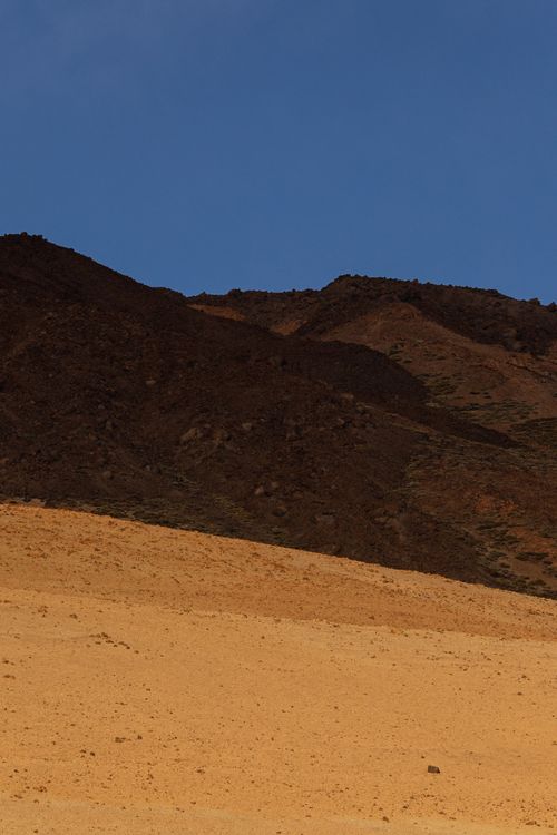 Free Beautiful view of sand dunes and rocky hills under a clear blue sky, capturing the essence of a desert scene. Stock Photo