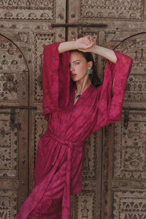 Model in a Pink Floral Robe in Front of an Antique Wooden Gate