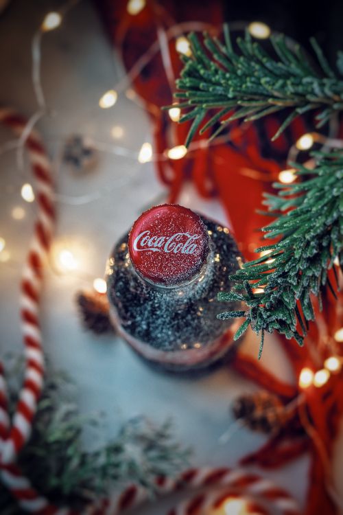 Free Close-up of a frosty Coca Cola bottle surrounded by Christmas decorations in a winter theme. Stock Photo