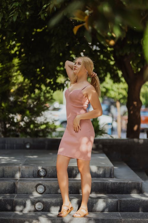 Blonde Woman in Pink Strap Dress Posing in a Park