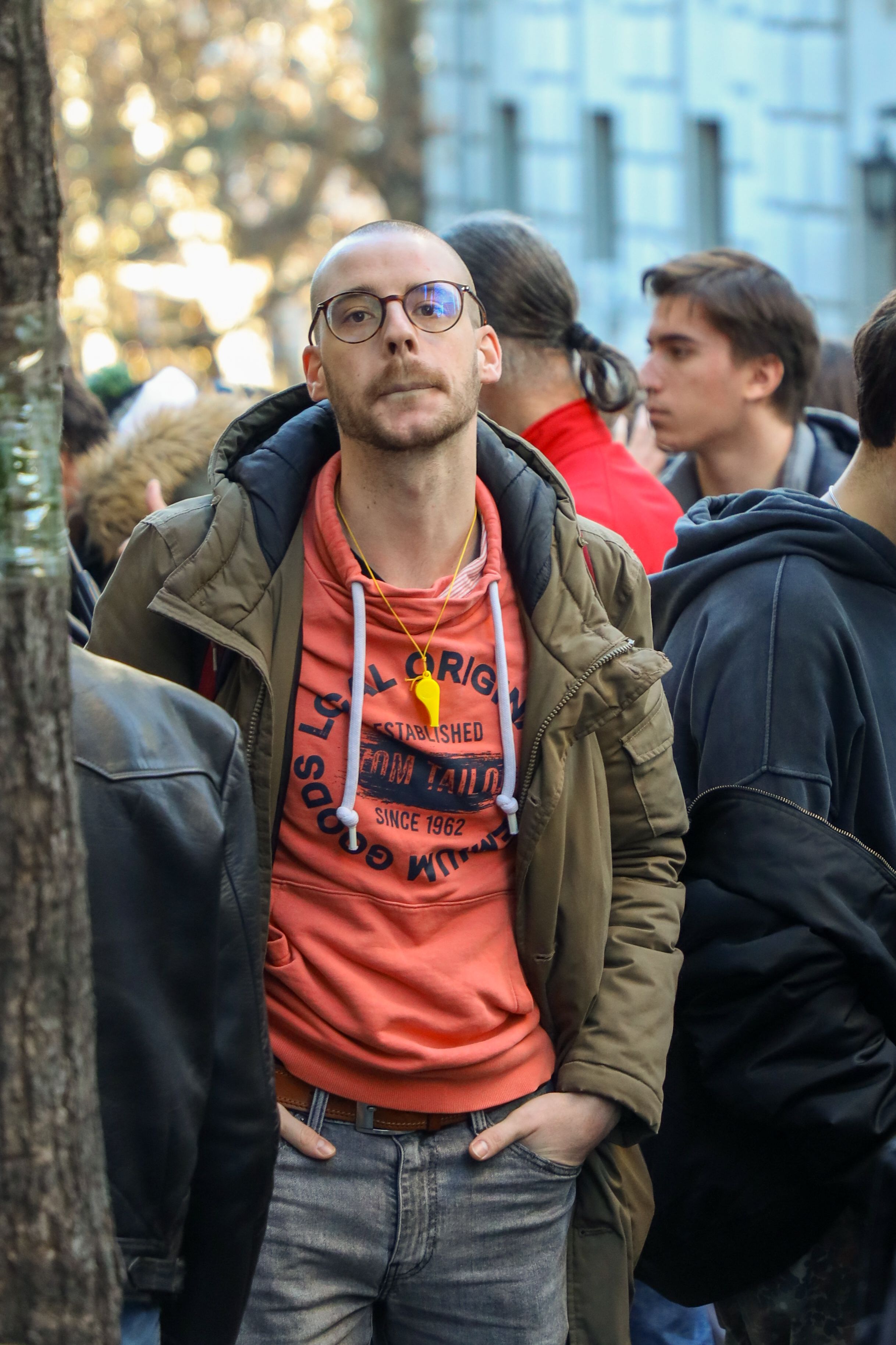 Group of adults in urban setting, showcasing casual street fashion with colorful clothing.