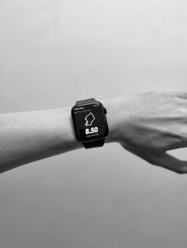 Monochrome photo of a smartwatch displaying workout details on a wrist.