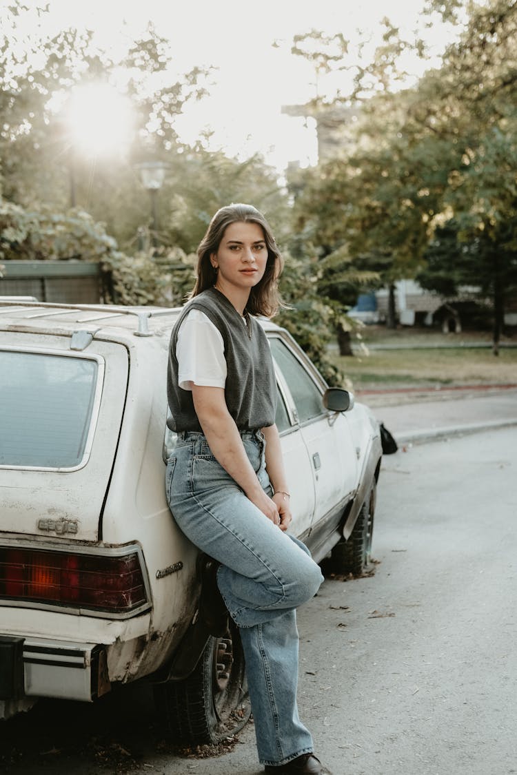 Girl Wearing Jeans Leaning On A Car 