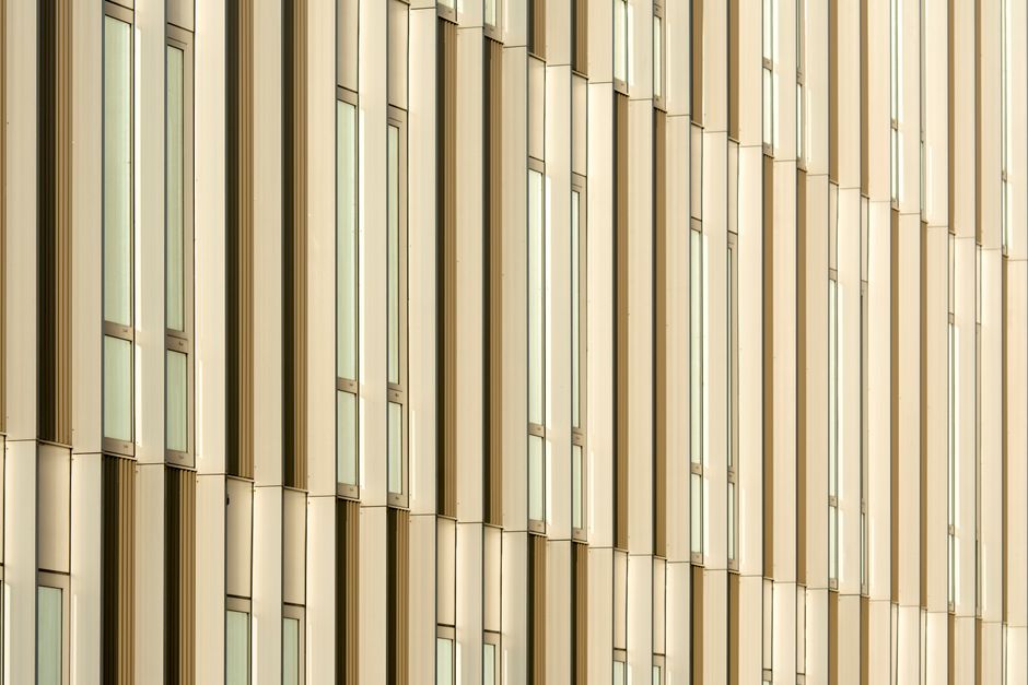 Capturing the sleek design of a modern glass facade with reflective windows.