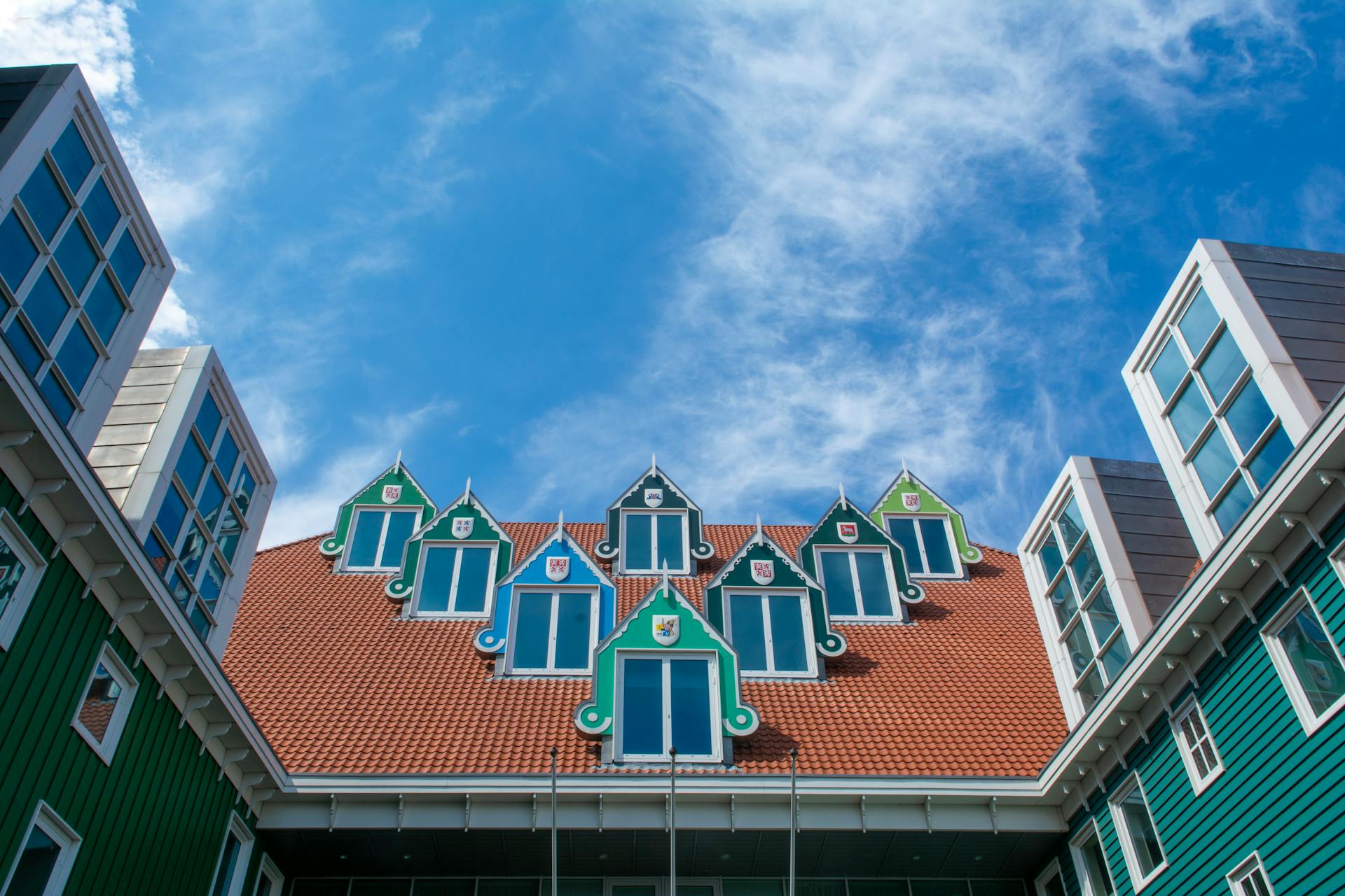 Striking Dutch-style building with colorful dormer windows and a red roof in Zaandam.