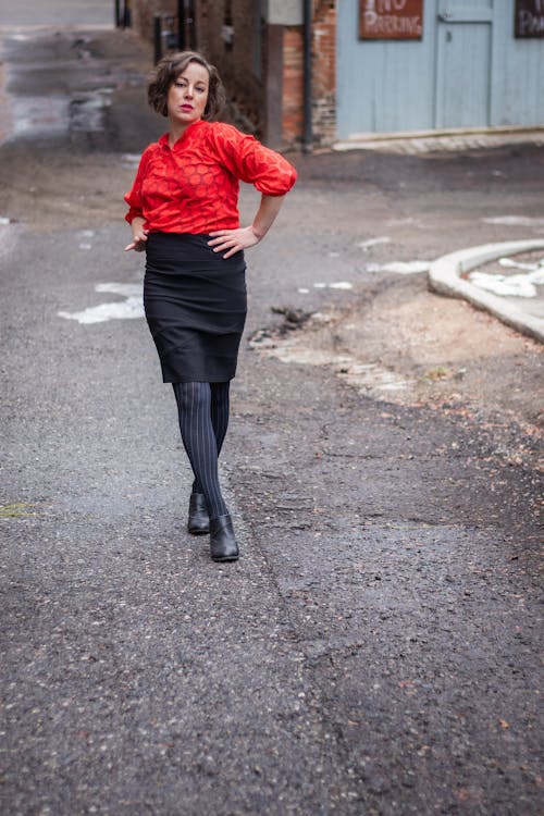 Brunette Woman in Red Blouse and Black Skirt Walking on Street