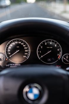 Detailed shot of a BMW car dashboard highlighting the speedometer and steering wheel.