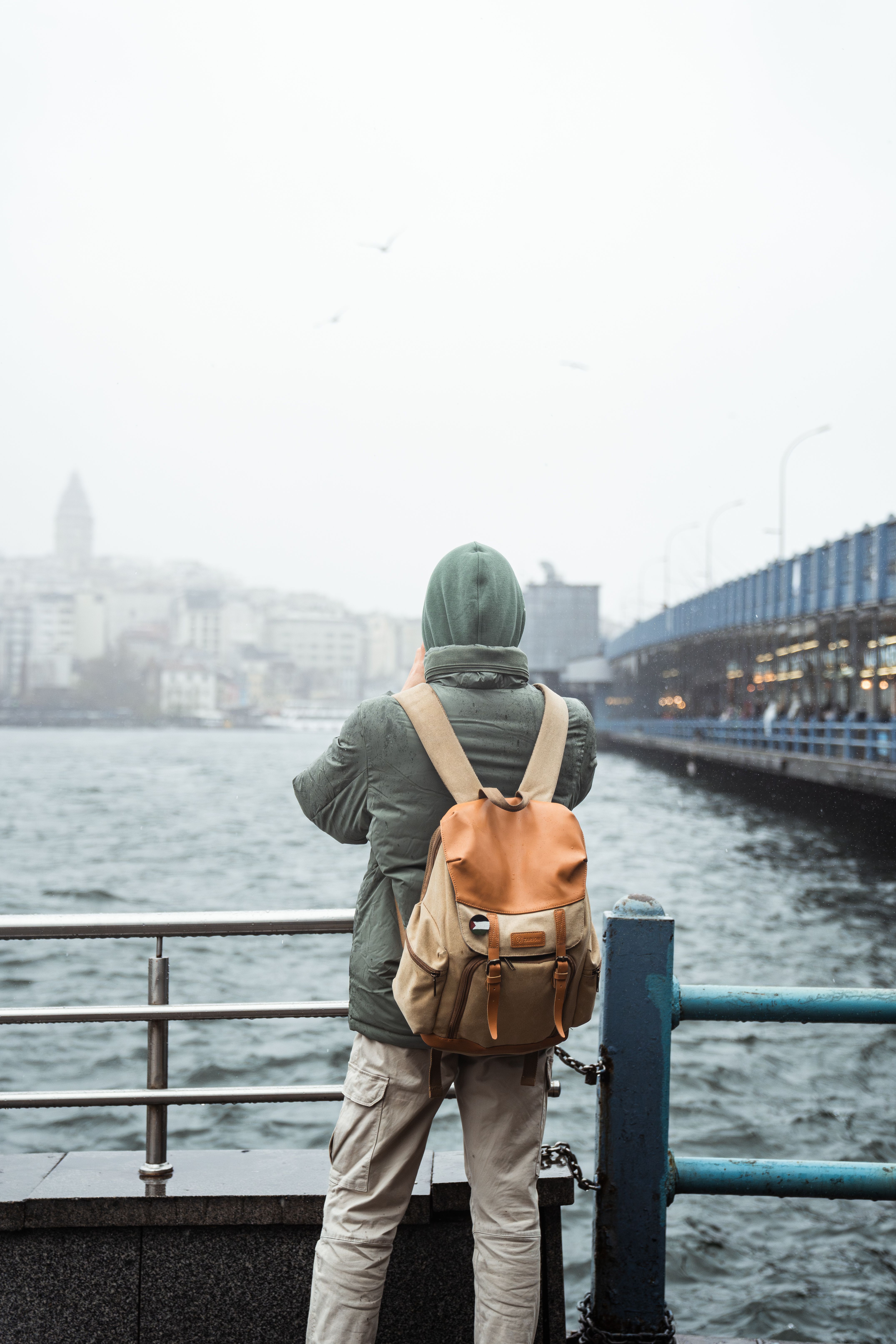 Solo traveler with a backpack looking out over a bay
