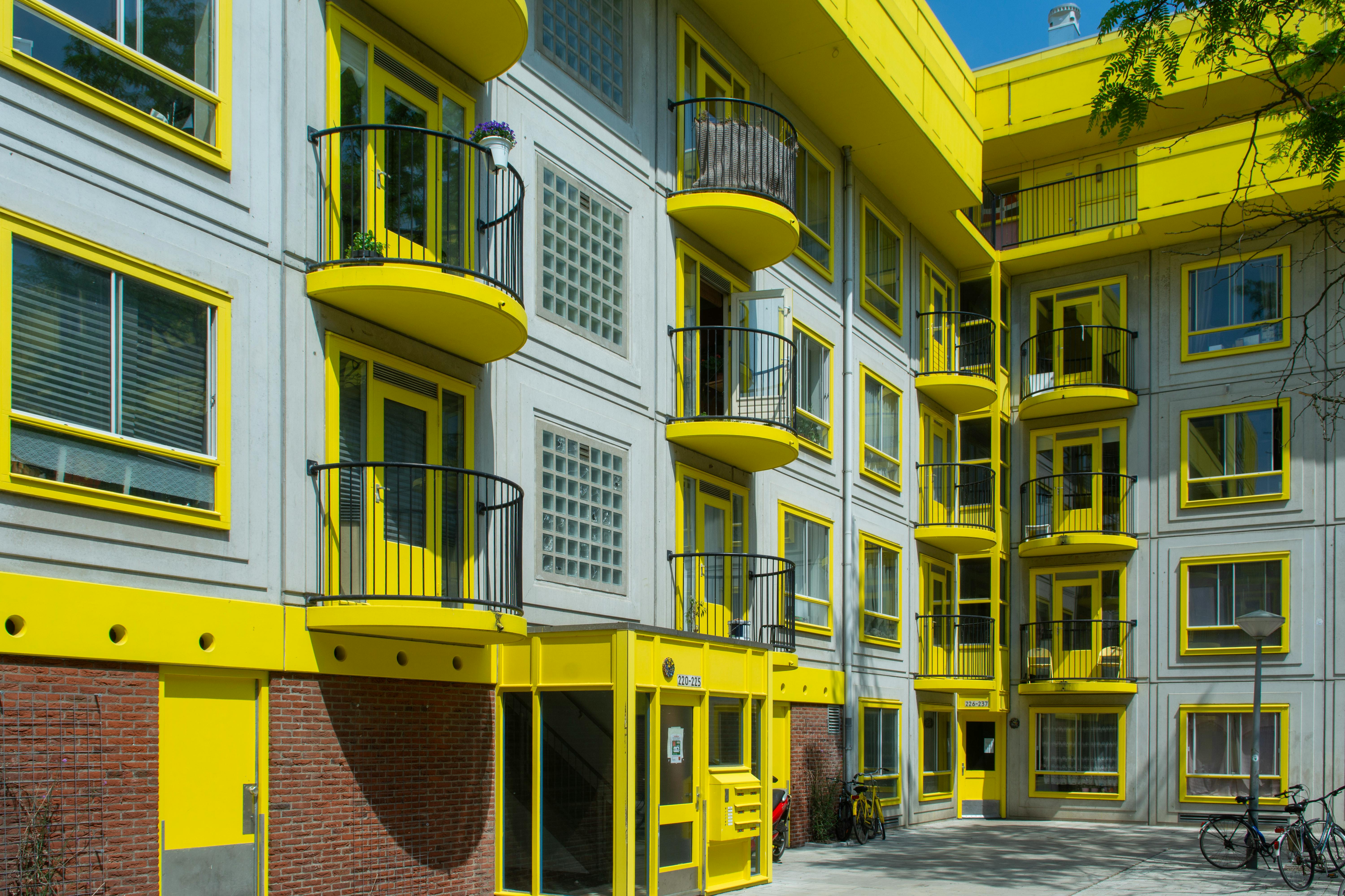 Hollanda'daki konut piyasasını ve kira durumunu temsil eden, Amsterdam'ın ikonik kanal kenarı evleri ve modern yerleşim alanları.