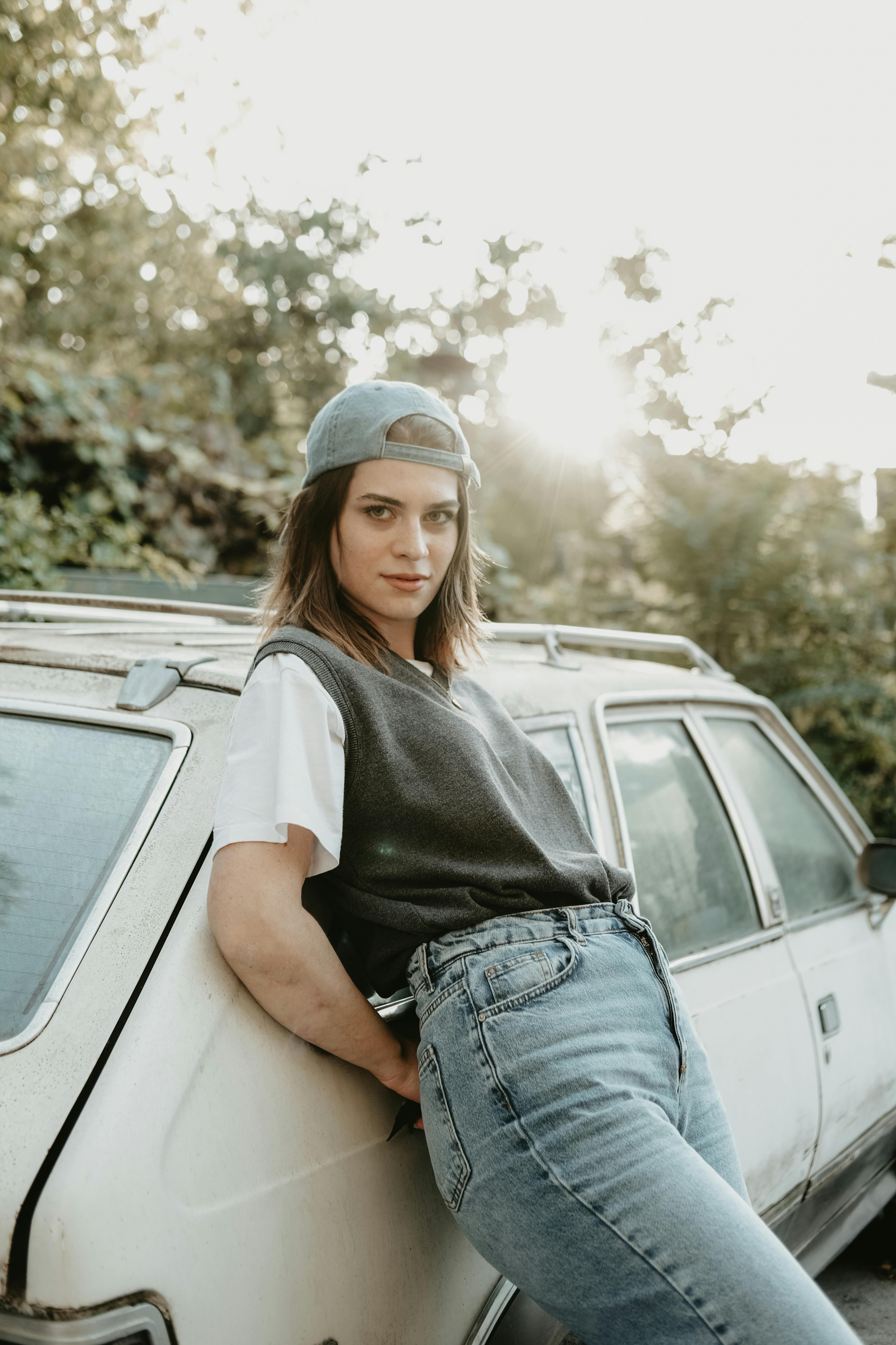 Premium Photo | Beautiful young fashionable rszyeuk woman with cool yellow  sunglasses wearing fashionable summer clothes with a top pink jeans and  sneakers sits on a yellow vintage car and fixes her
