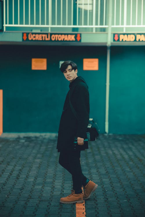 Man in Black Coat and Pants Posing on a Street