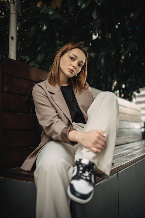 Model in a Light Brown Blazer and Gray Pants Sitting on a Bench