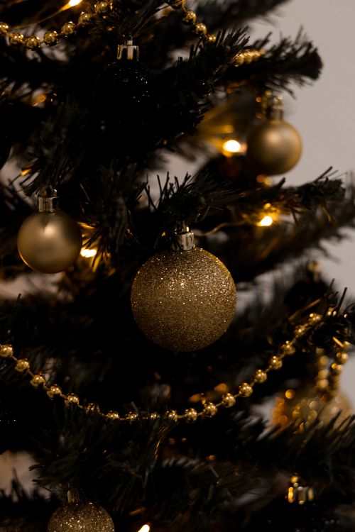 Free Close-up of golden baubles and lights on a decorated Christmas tree, capturing the festive spirit. Stock Photo