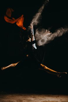 A powerful leap captures the essence of dance and movement in dramatic lighting.