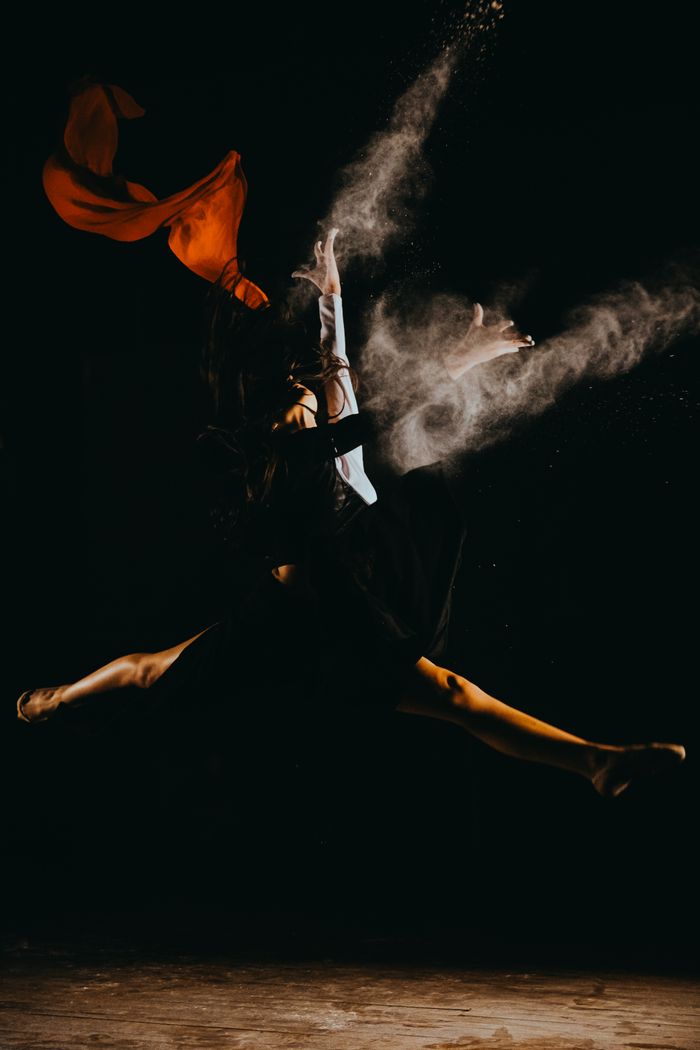 A dancer captured mid-leap in dramatic light — photo by Osman Arabaci on Pexels