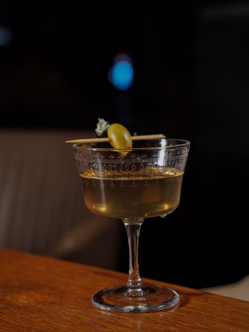 Free Sophisticated cocktail in a crystal glass garnished with an olive, perfect for gourmet presentations. Stock Photo