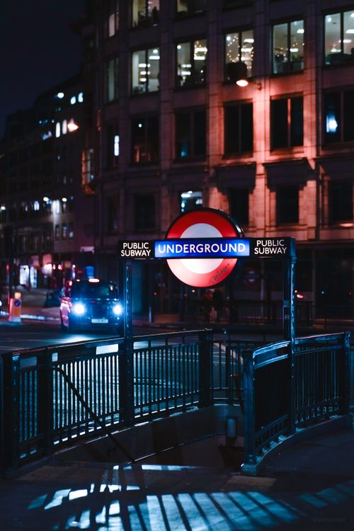 Free Night view of a London Underground subway entrance with vibrant city lights. Stock Photo