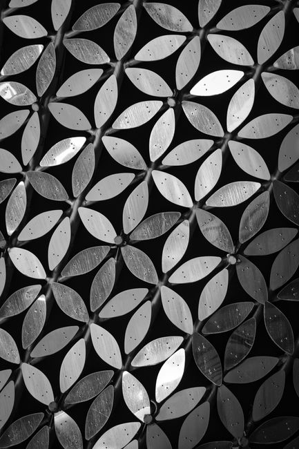 Intricate geometric metal design in black and white, close-up view.