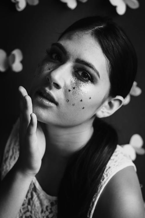 Grayscale Photo of Woman With Facial Art