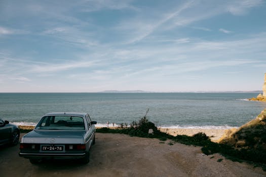 Classic Mercedes parked by a serene coastline, perfect for vintage travel vibes.