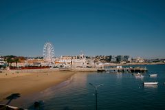 A stunning aerial view of Cascais with its beach, Ferris wheel, and historic buildings by the sea.