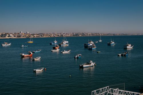 Free A serene harbor with various boats floating on a calm sea under a clear sky. Stock Photo