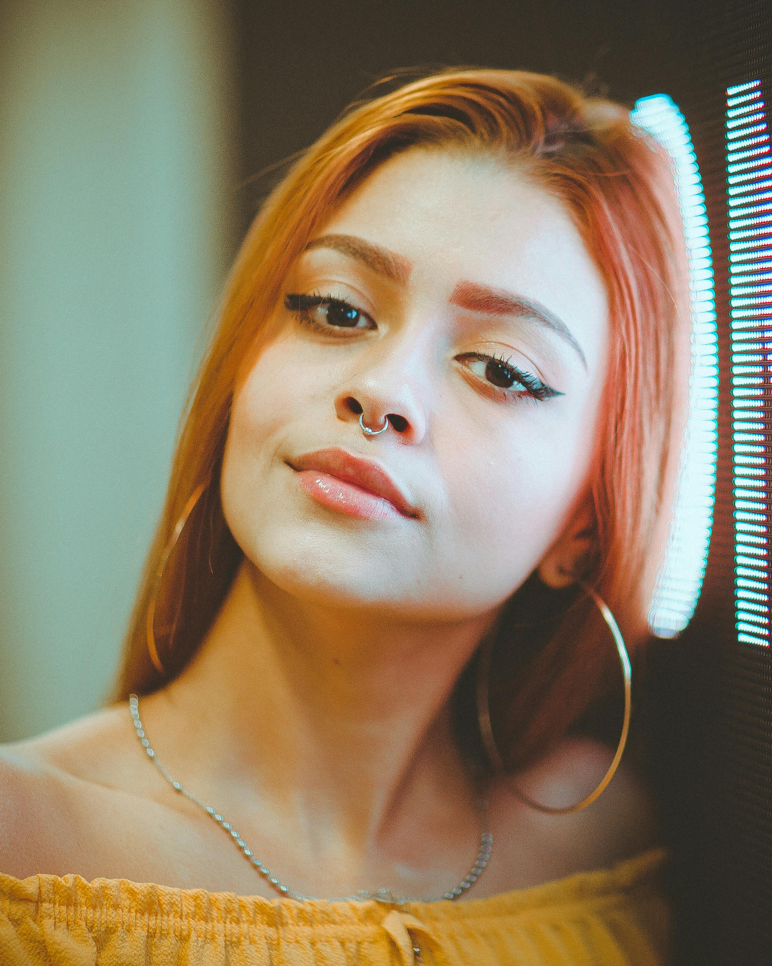 这是一幅自信女性的特写肖像，她戴着鼻环，妆容鲜明