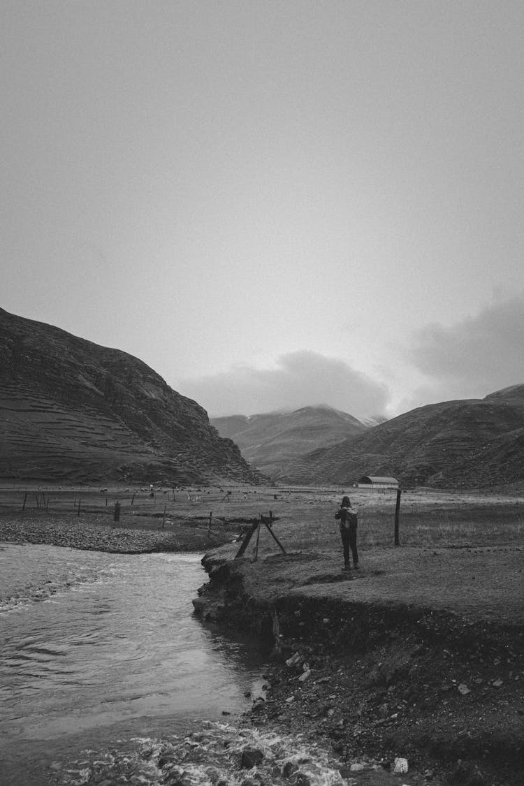 Man Photographing A River In Black And White