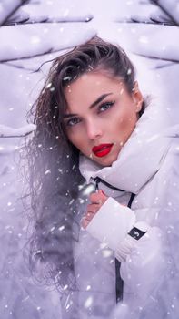 Stunning portrait of a woman in a snowy setting, showcasing fashion and beauty.