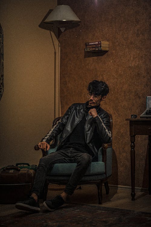 Man Sitting in an Armchair in a Leather Jacket