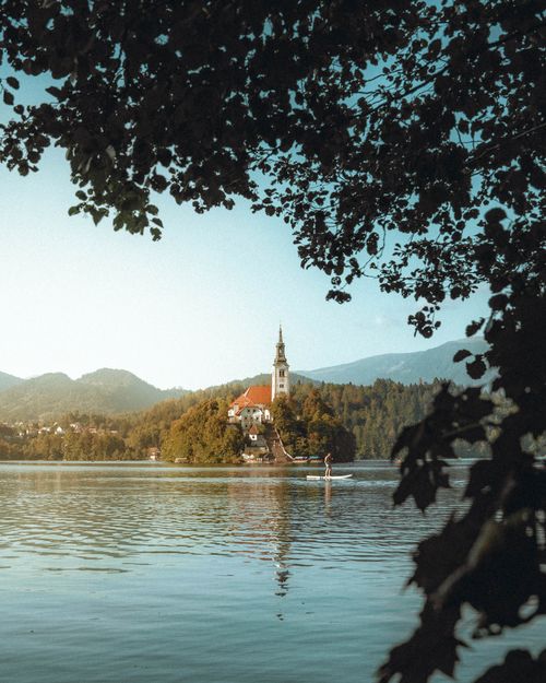 Free Idyllic scene of Lake Bled with a distant view of the iconic island church surrounded by serene waters. Stock Photo