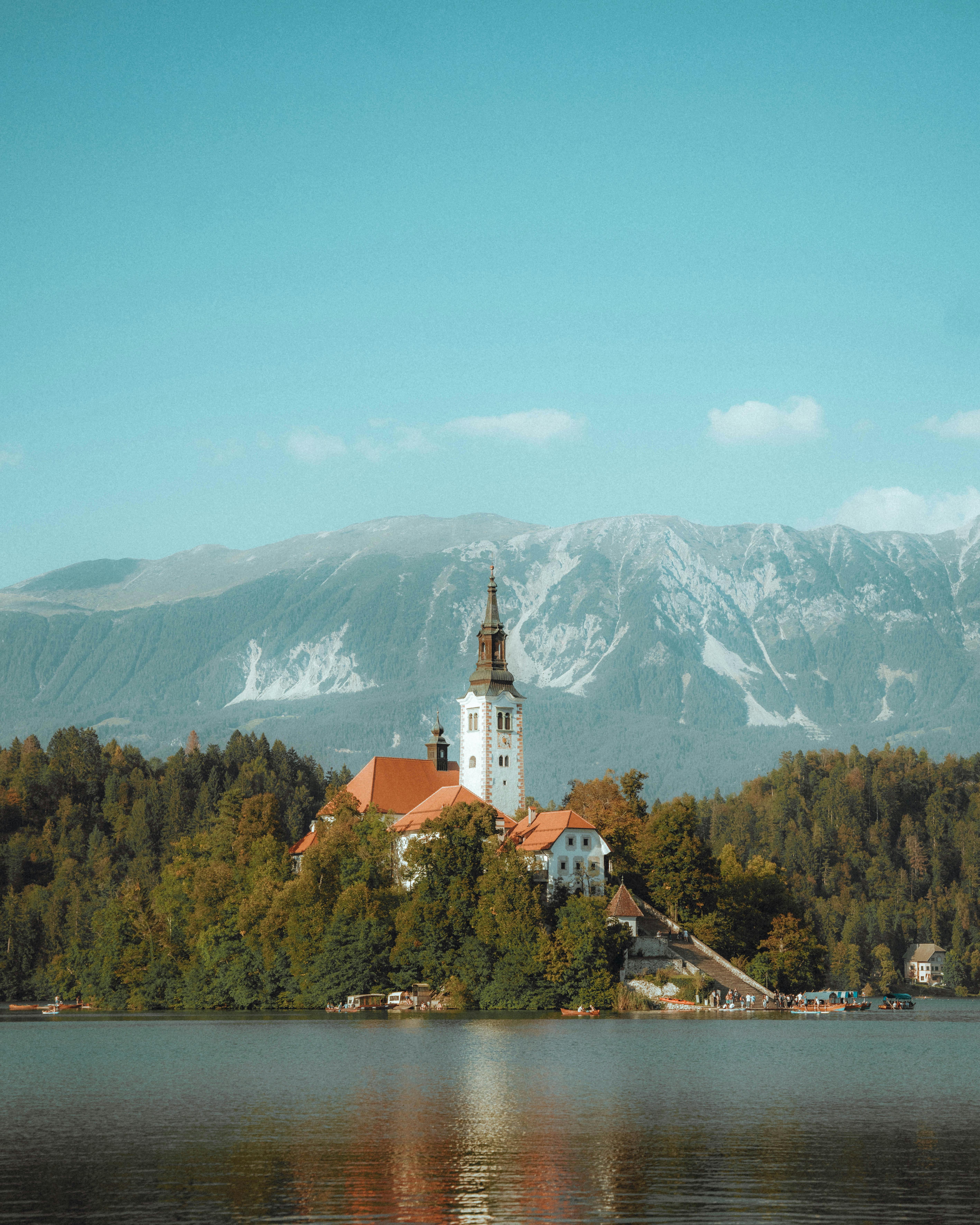Free Scenic view of the Church of the Assumption on Lake Bled in Slovenia with mountains in the background. Stock Photo