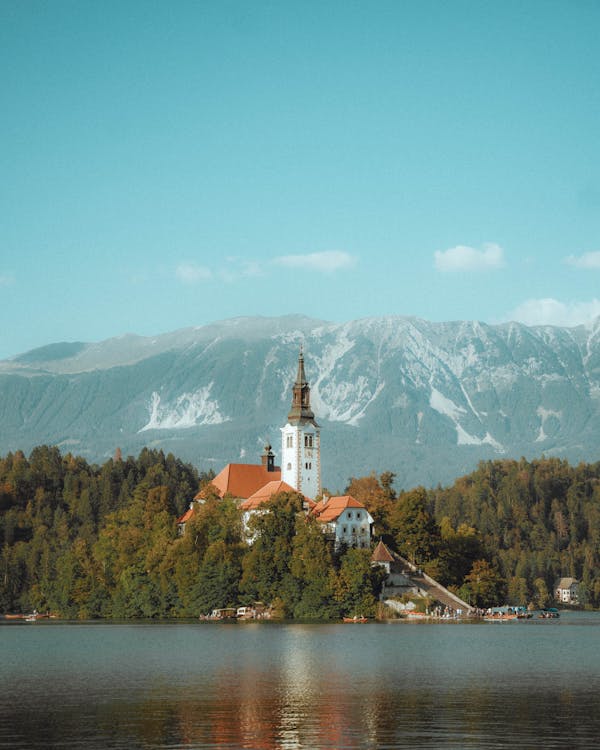 Free Scenic view of the Church of the Assumption on Lake Bled in Slovenia with mountains in the background. Stock Photo