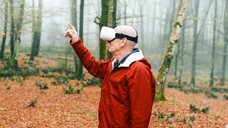 Man With A Virtual Reality Headset On His Head Standing In The Autumn Forest 