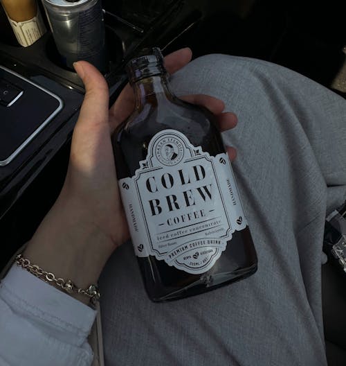 Hand Holding Bottle of Gold Bre Coffee