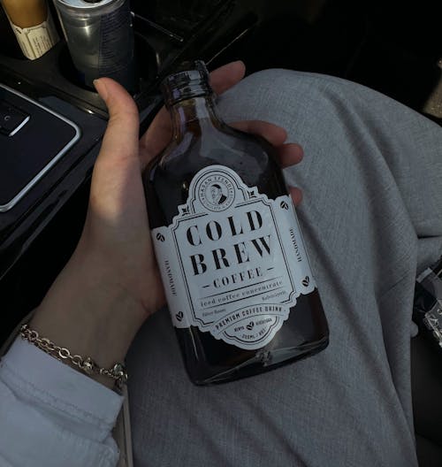 Free Hand Holding Bottle of Gold Bre Coffee Stock Photo