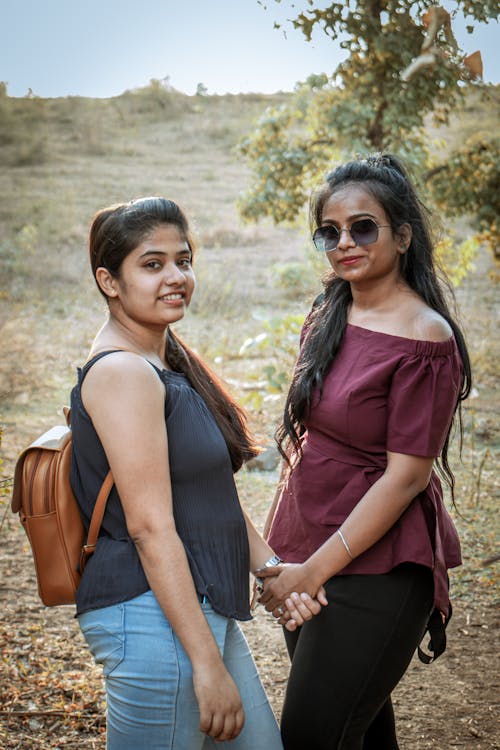 Young Women with Backpacks Posing together in the Wilderness 