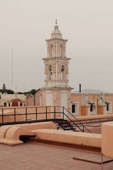 Elegant colonial bell tower on rooftop in Puebla, Mexico.
