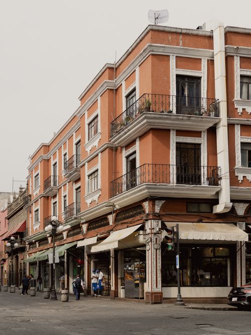 Free Charming colonial-style building in Heroica Puebla de Zaragoza displays vibrant colors and bustling street scene. Stock Photo