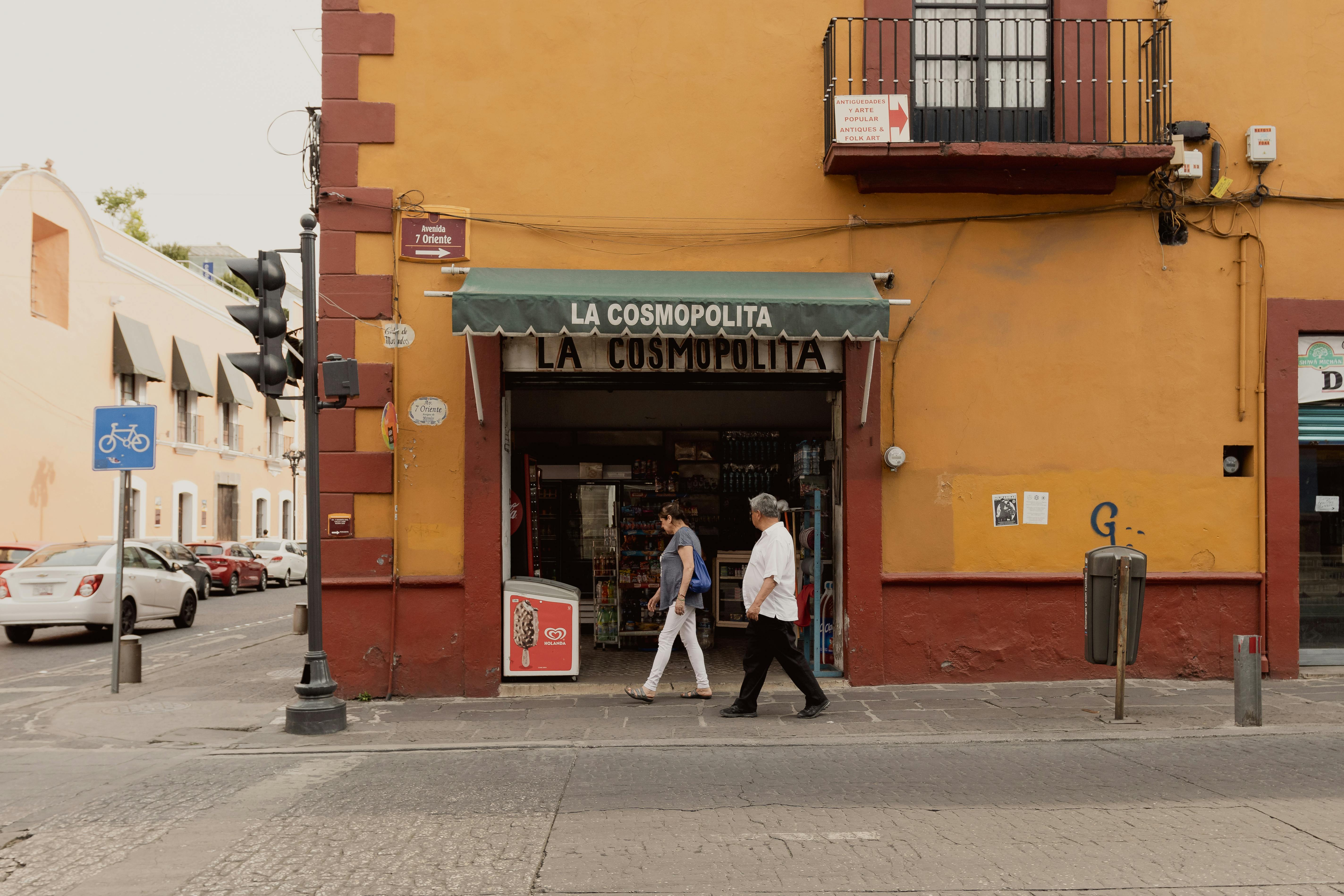People walking past La Cosmopolita store in Puebla, Mexico, during the day.