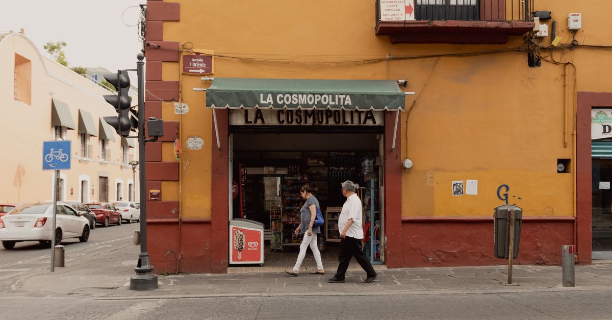 People walking past La Cosmopolita store in Puebla, Mexico, during the day.